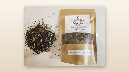DipSomeTea pure and organic chai 8 oz kraft pouch beside a pile of loose spiced black tea with green cardamom pods, framed on a soft cream background